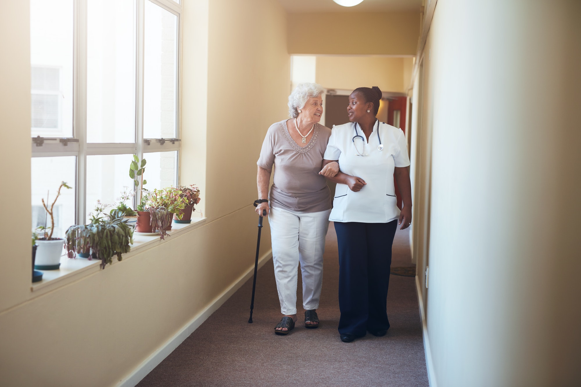 Das Bild zeigt eine Pflegekraft mit Patient*innen.