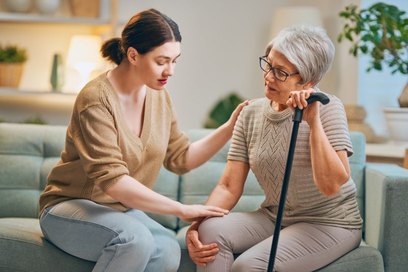 Das Bild zeigt eine Pflegekraft mit Patient*innen.